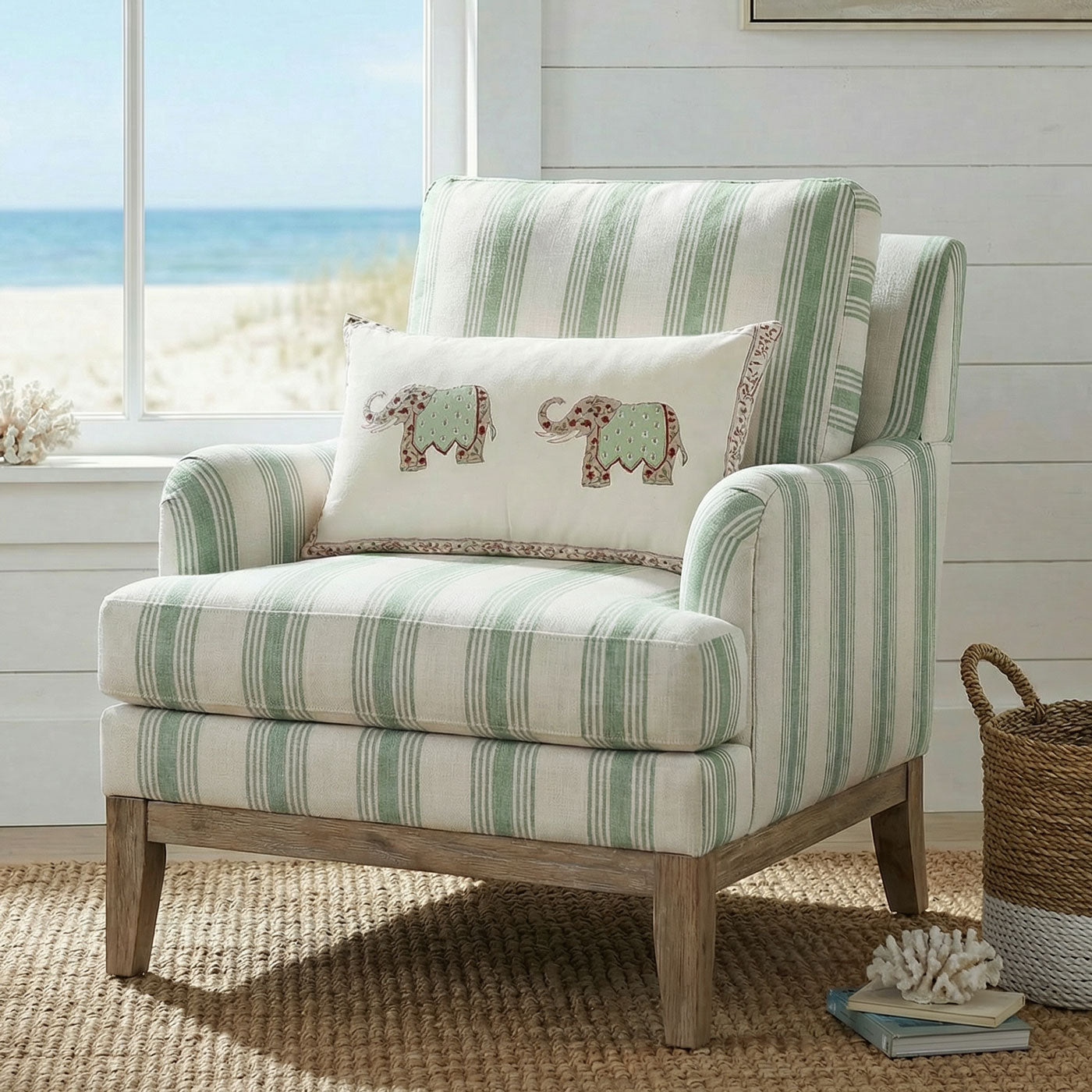 Striped armchair with a decorative pillow featuring elephant designs, placed in a room with a window view of the beach.