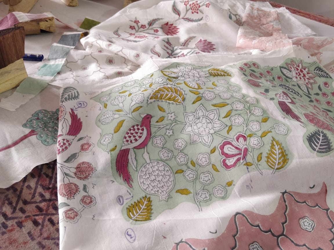 Handmade quilt and cotton cushion covers styled on a bed