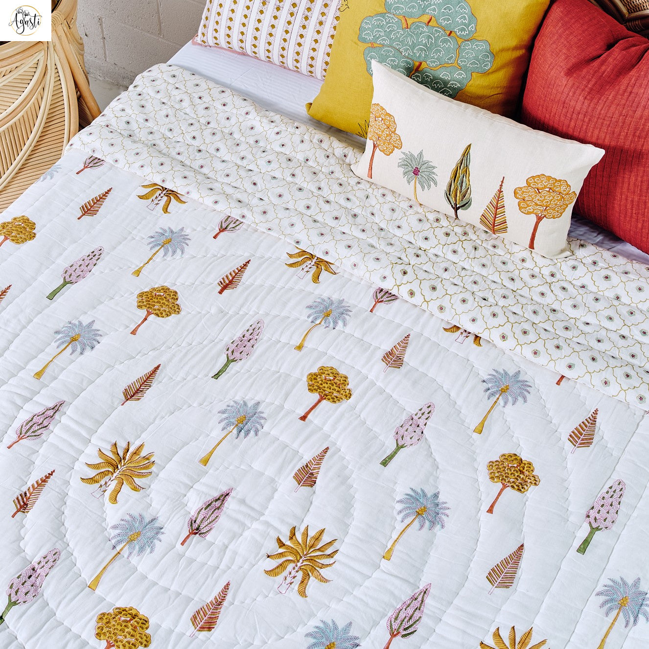 Reversible hand-block printed quilt in neutral sand tones on a styled bed